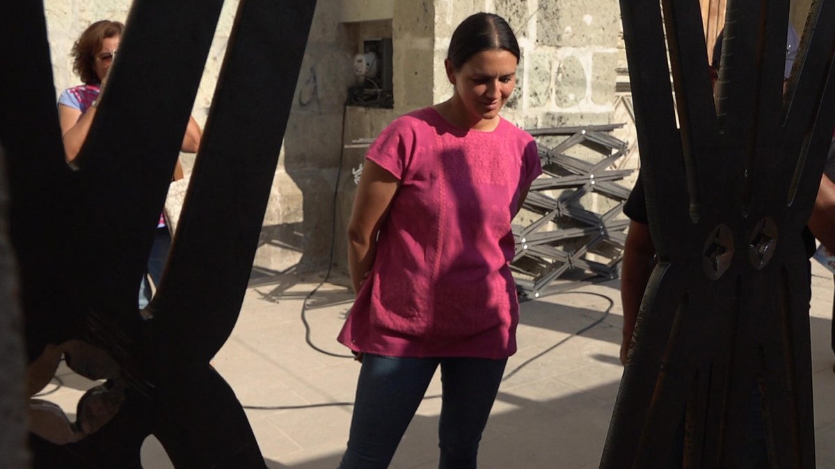 Sara López Ellitsgaard, hija del artista plástico mexicano Francisco Toledo, observa una obra de su padre en el templo de San Felipe Neri, este viernes en el estado de Oaxaca (México). EFE/ Jesús Méndez