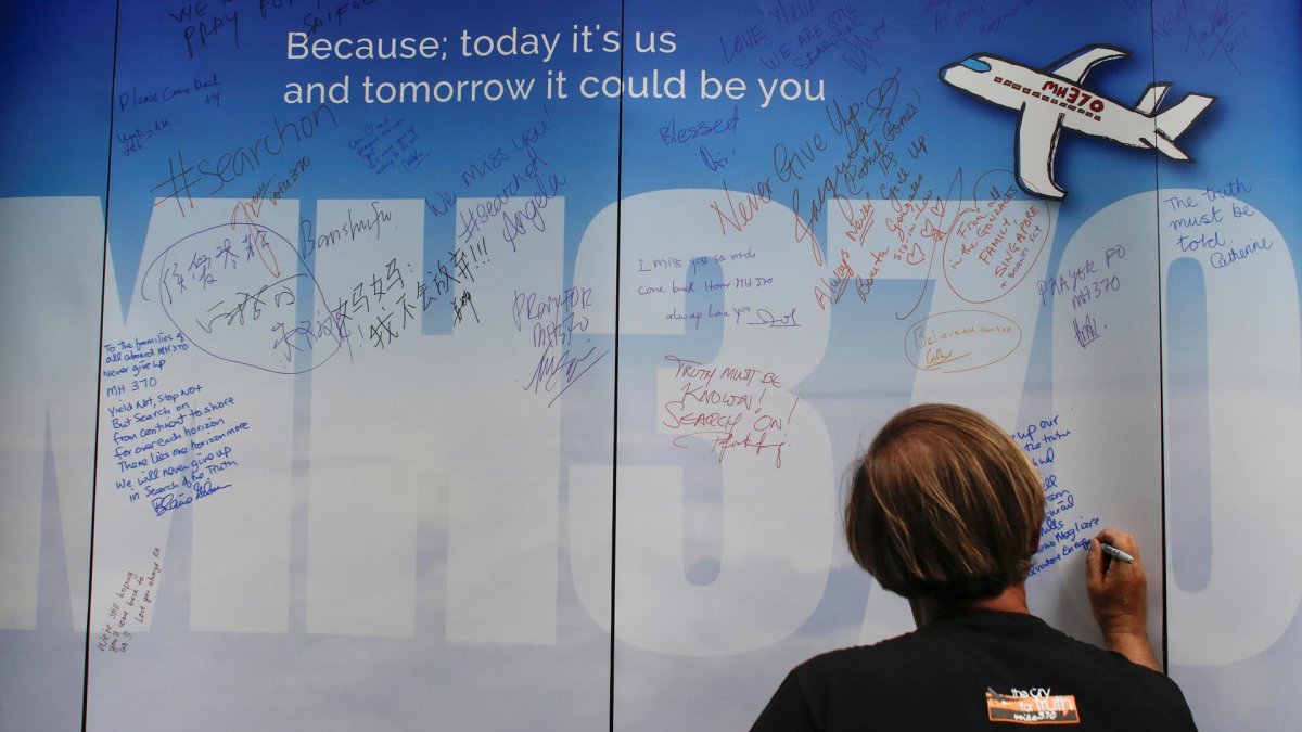 Fotografía de archivo donde una mujer escribe un mensaje dedicado para los pasajeros desaparecidos del avión MH370 de Malaysia Airlines, en el Aeropuerto Internacional de Kuala Lumpur, Malasia, 6 de marzo de 2016. 
                      EFE/ Fazry Ismail