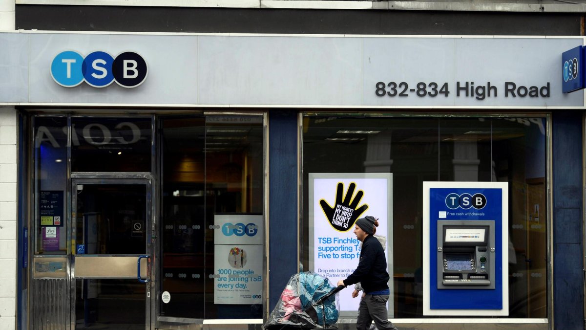 Una pareja camina junto a una sucursal del banco británico TSB en Londres, Reino Unido. EFE/Neil Hall/Archivo