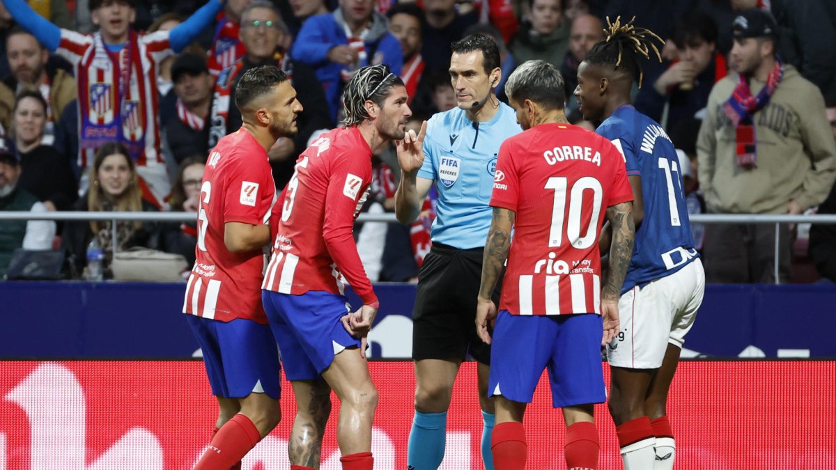 Jugadores del Atlético de Madrid conversan con el árbitro Martínez Munuera durante un partido de la Liga española. EFE/Mariscal