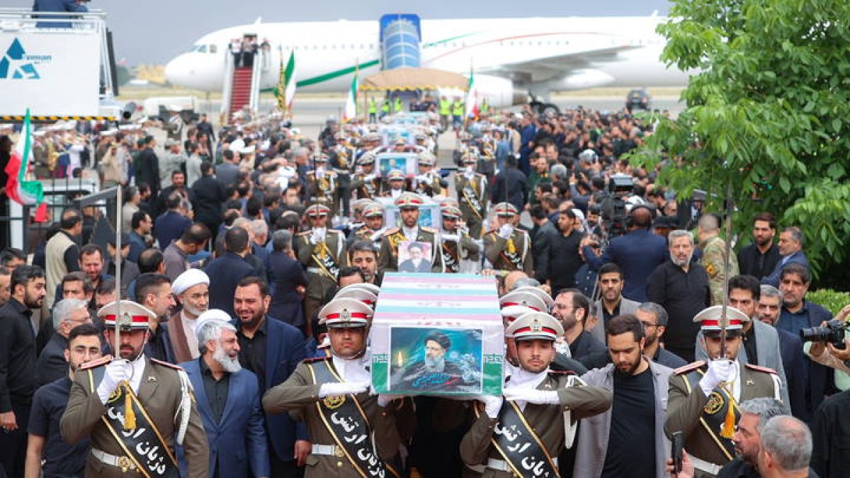 A handout photo made available by the Iranian Presidential Office shows Iranian soldiers carrying the coffins of late president Ebrahim Rais