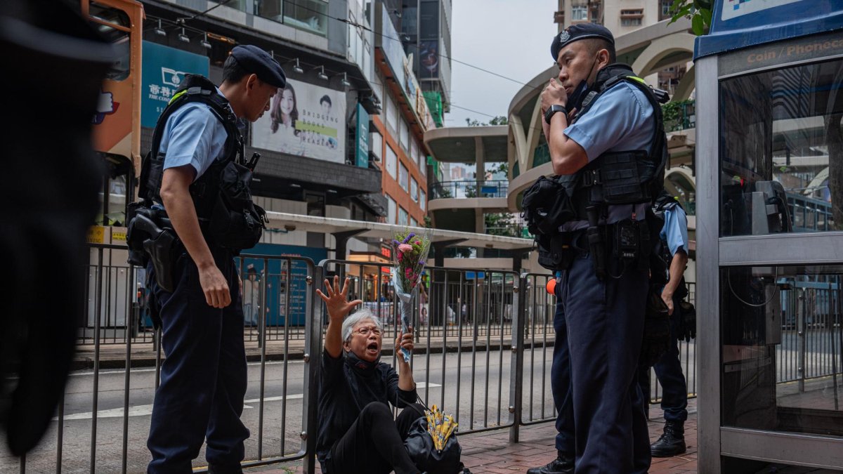 Alexandra Wong (C), una activista conocida como Abuela Wong, se sienta en el suelo antes de ser detenida por agentes de policía en Causeway Bay, cerca de Victoria Park en Hong Kong, el 4 de junio de 2024. Durante más de tres décadas, miles de personas se congregaban en el emblemático Parque Victoria de Hong Kong para conmemorar, de forma pacífica y a la luz de las velas, a las víctimas de la represión, una tradición que se celebró por última vez en 2019 y que ahora ha sido reemplazada por un 