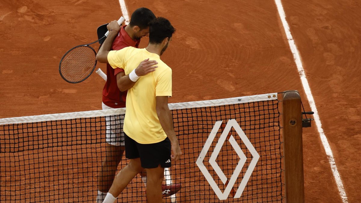 El serbio Novak Djokovic de Serbia (i) se abraza con el argentino Francisco Cerundolo de Argentina tras ganar su partido en Roland Garros, en París, Francia. EFE/EPA/YOAN VALAT
