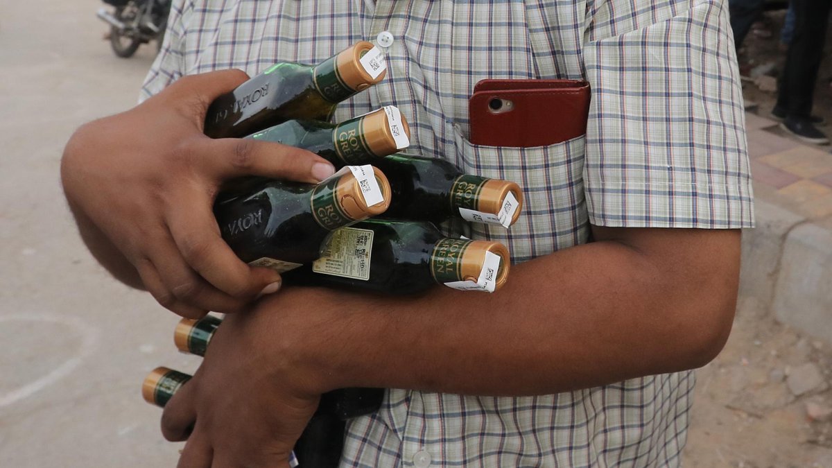 Imagen de archivo de un ciudadano indio con varias botellas de alcohol en Nueva Delhi. EFE/EPA/RAJAT GUPTA