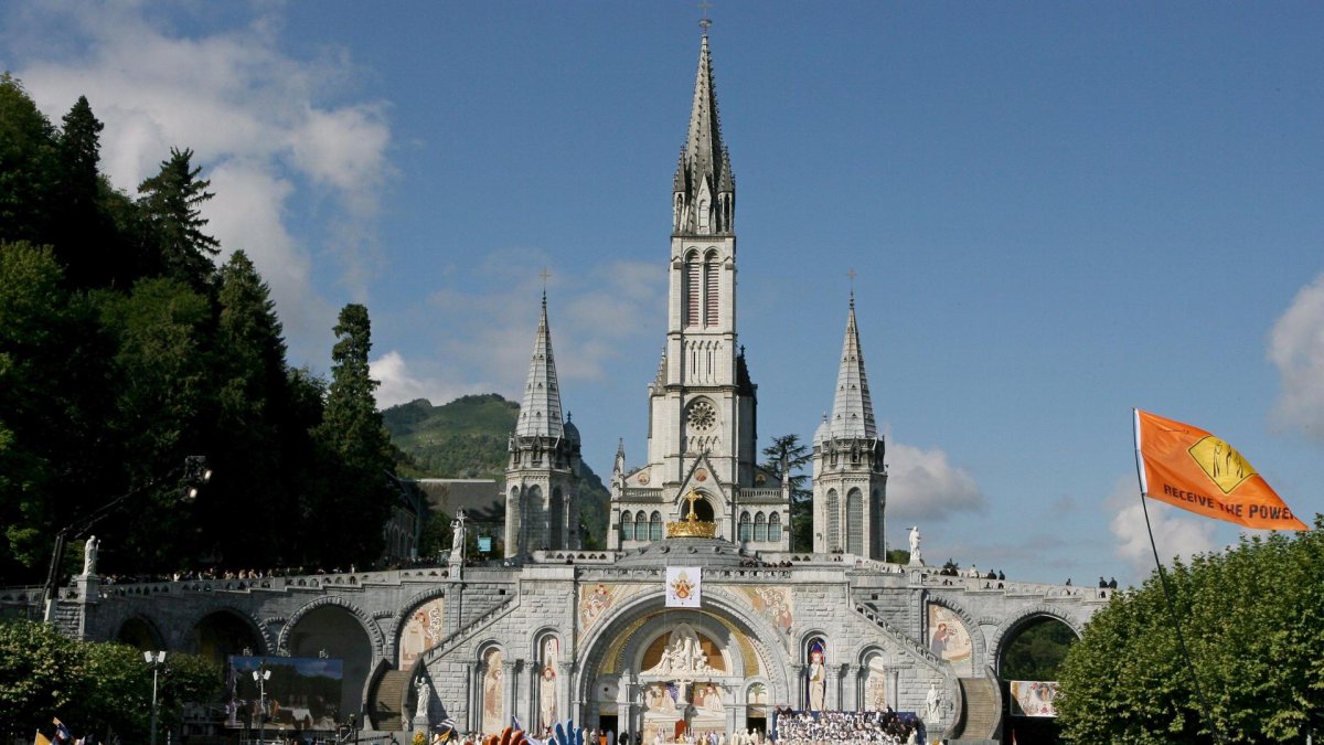 Un grupo de peregrinos ante la basílica de Lourdes. EFE/Guillaume Horcajuelo