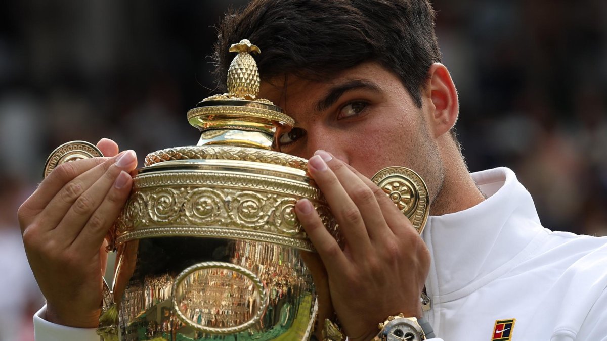 El español Carlos Alcaraz besa el trofeo tras vencer a Novak Djokovic en la final del torneo de Wimbledon. EFE/ADAM VAUGHAN