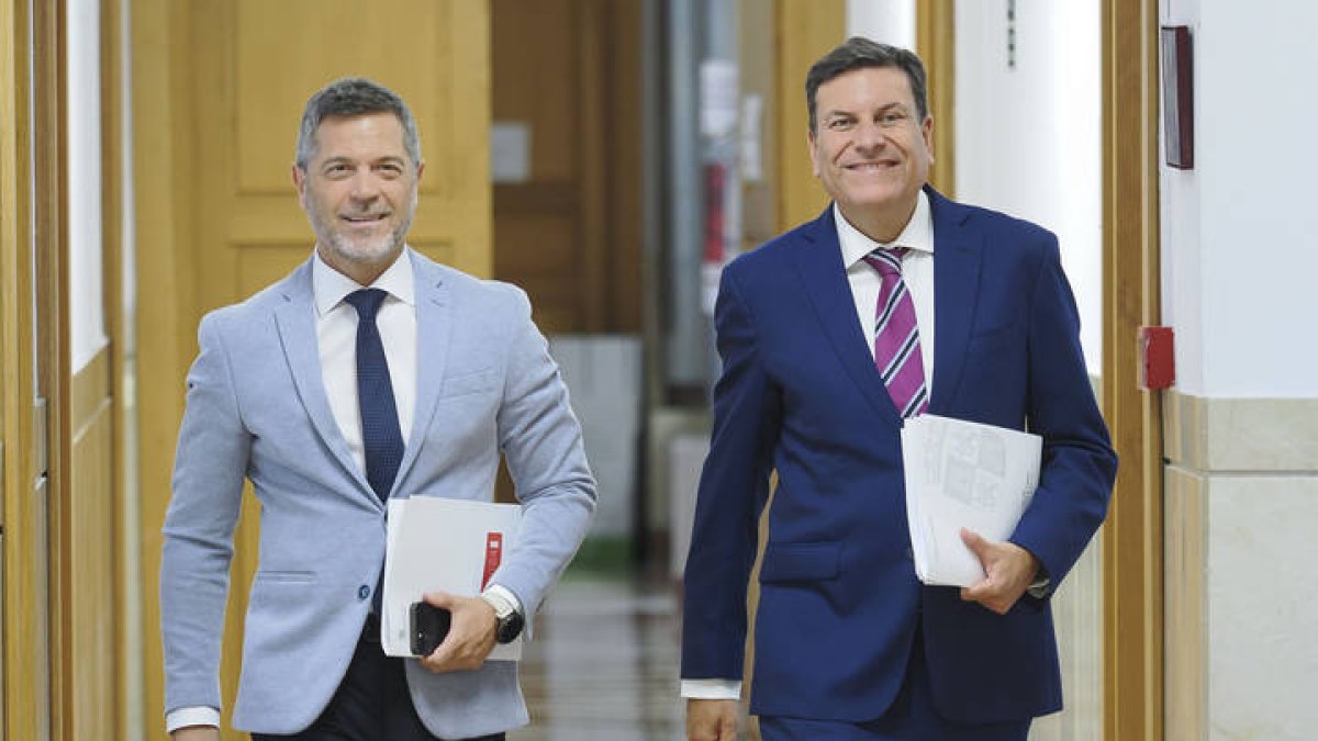El consejero de Economía y Hacienda y portavoz, Carlos Fernández Carriedo (d), se dirige a comparecer en rueda de prensa tras la reunión del Consejo de Gobierno, este jueves en Valladolid.