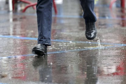 Un hombre camina por el pavimento empapado. RAQUEL MANZANARES