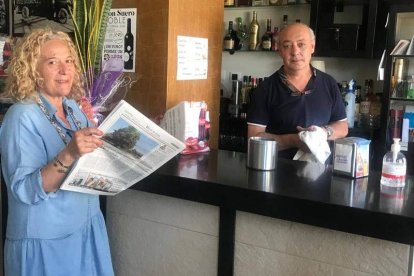 Camino Urdiales, con su ejemplar del Diario de León, junto a su marido, Tomás Franco, en la barra del Café de María. DL