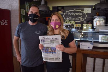 Toño y Miriam posan con el ejemplar del Diario de León de la cafetería Bohemia, del cual pueden disfrutar todas las personas que se acercan a este céntrico bar de La Bañeza. A. RODRÍGUEZ