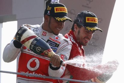 Lewis Hamilton y Fernando Alonso celebran su primer y tercer puesto, respectivamente, logrados en el circuito de Monza.