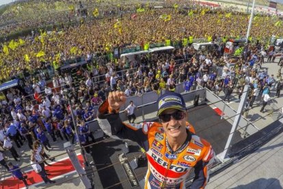 Dani Pedrosa celebra  con la hinchada de Valentino Rossi a su espalda  su victoria en Misano.