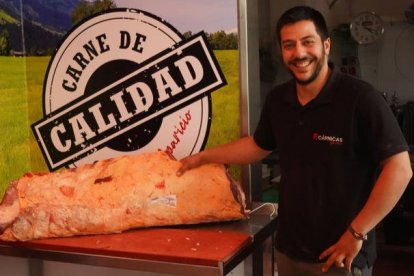 Pablo Aparicio posa con una pieza de carne en su carnicería en Veguellina de Órbigo. J. NOTARIO