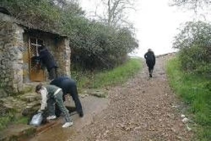 Unas personas recogen agua en una fuente cercana al lugar donde fueron encontrados los explosivos