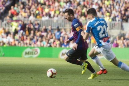 Messi, perseguido por Marc Roca en una acción del derbi.