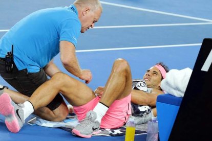 Nadal es atendido por el médico. El balear tuvo que abandonar en el quinto set frente a Cilic. CRISTINO