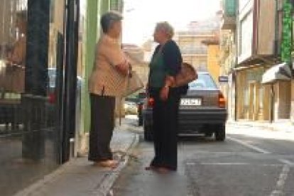 Dos mujeres conversan en la calle de Fernández Cadórniga. Sólo una de ellas puede ocupar la acera