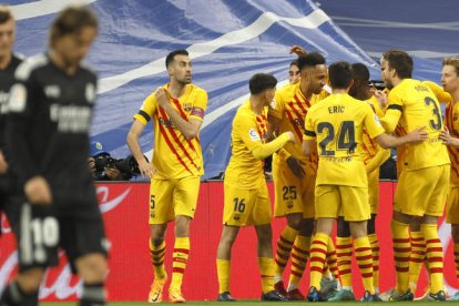 Los jugadores del FC Barcelona celebran la victoria del equipo blaugrana ante Kroos y Modric, cabizbajos después de la exhibición culé en el Bernabéu. BALLESTERO