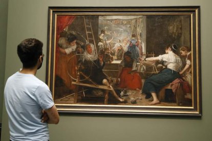 Un visitante observa ‘Las hilanderas’, de Velázquez, a su tamaño original. JAVIER LIZÓN