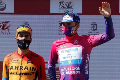 Remco Evenepoel escoltado en el podio por Mikel Landa. SANTI OTERO