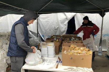 Dos voluntarios preparan bolsas con productos enlatados. GERVASIO SÁNCHEZ