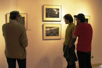 Un grupo de ex mineros busca caras conocidas en las fotografías expuestas.