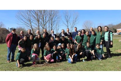 Los niños y niñas de sexto de Primaria, junto a sus profesores, directora y directivos de la empresa, y abajo el alcalde de La Robla, plantando su árbol. DL