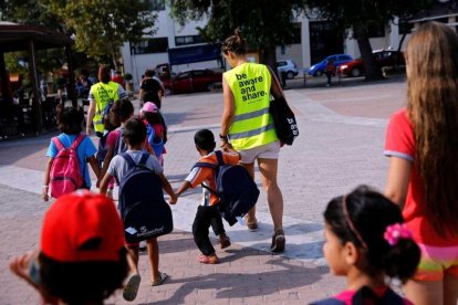 Unos voluntarios acompañan a la escuela a niños refugiados en la isla griega de Chios.