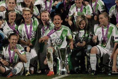 Las jugadoras del Wolfsburgo posan sobre el cédped con el trofeo de campeonas de Europa.