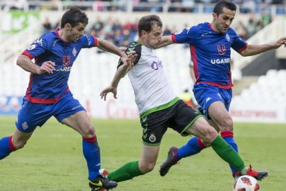 Julen Castañeda, con la elástica del Racing de Santander, se lleva un balón a pesar de la oposición de los contrarios. ROBERTO RUIZ / EL DIARIO MONTAÑÉS