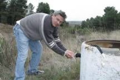 El pedáneo, Belarmino Domínguez, toma agua en sus manos del sondeo que abastece al pueblo