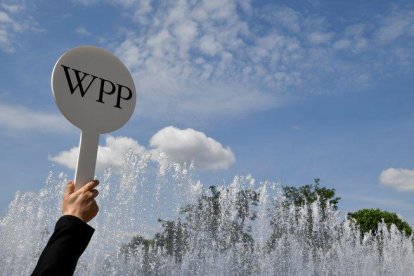 Un guía de la firma WPP en Londres atrae a los congregados con el logo de la compañía.