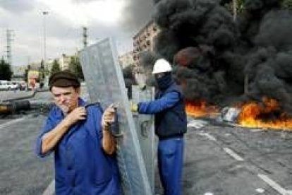 Un par de trabajadores de Izar en Bilbao preparan barricadas para seguir con sus protestas