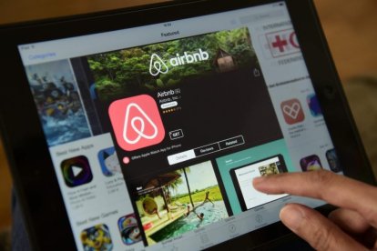 Una mujer navega por la página de Airbnb en una tablet, en Berlín.