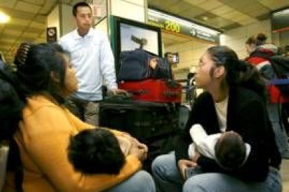 Un grupo de viajeros ecuatorianos esperan en la Terminal 1 de Barajas