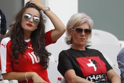 La madre de los hermanos Xhaka, con una camiseta dividida con los colores suizos y albaneses, junto a la pareja del suizo Granit.