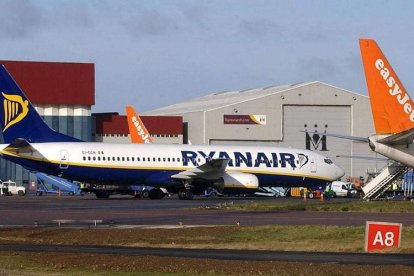 Aviones de Ryanair e Esayjet esperan en un hangar.