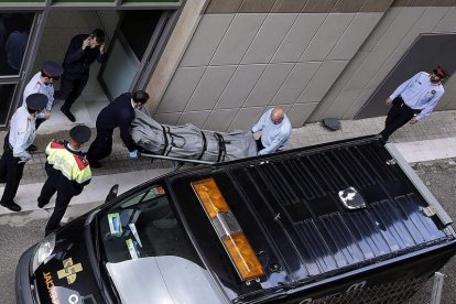 Miembros de los servicios funerarios retiran el cadáver del profesor.