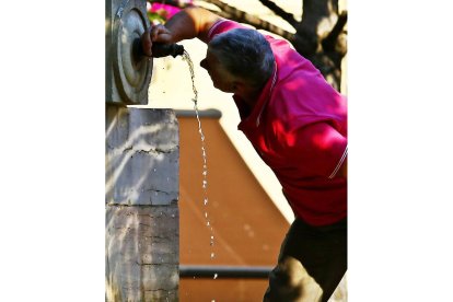 Un hombre se refresca en una fuente de León