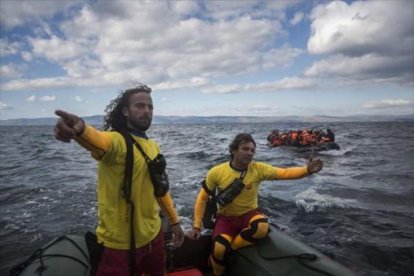 Dos miembros de Proactiva Open Arms socorren a refugiados en el Egeo.