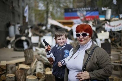 Un niño con una pistola de juguete y una mujer posan ante una barricada en la localidad ucraniana de Slaviansk, este jueves.