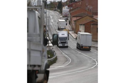 Camiones en una de las travesías de la N-120 entre León y Astorga. JESÚS F. SALVADORES