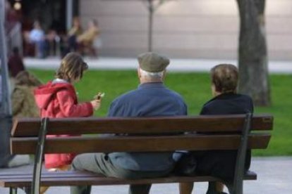 Una pareja de ancianos descansa en un banco en Ponferrada.