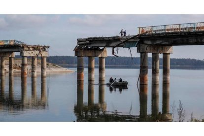 Civiles cruzan el río en bote bajo el puente dañado en Staryi Saltiv, la ciudad recién liberada en Jarkov. ATEF SAFADI