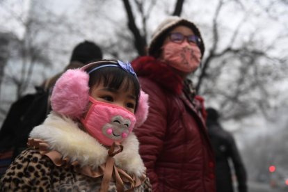 Una madre y su hija, por las contaminadas calles de Shijiazhuang, al norte de China, este miércoles, 21 de diciembre.