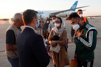 El ministro de la Presidencia, Félix Bolaños (2i), da la bienvenida a la jugadora afgana de baloncesto en silla de ruedas Nilofar Bayat (c) y a su marido (d) en la base aérea militar de Torrejón de Ardoz (Madrid), donde hoy viernes ha aterrizado el segundo avión fletado por España para evacuar a españoles y afganos del país asiático con 110 personas, entre ellas tres familias completas de personal de la Embajada. EFE/Mariscal POOL