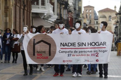 Estudiantes recorren el centro de León con la pancarta de Cáritas. FERNANDO OTERO