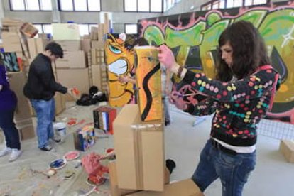 Una de las alumnas da forma a su obra, sobre una de las cajas dispuestas en el recinto.