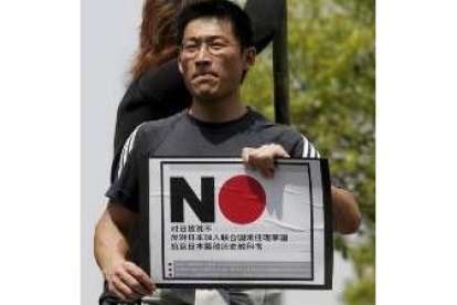 Un joven chino porta una pancarta en la que se pide el boicot a los productos japoneses