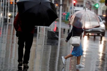 Varias personas se protegen de la lluvia